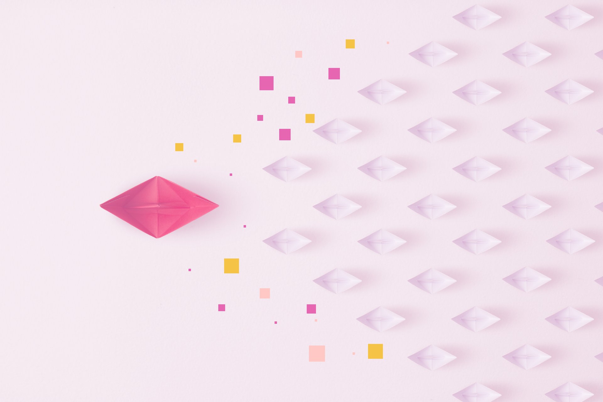 Small folded paper boats trailing behind a large pink paper boat